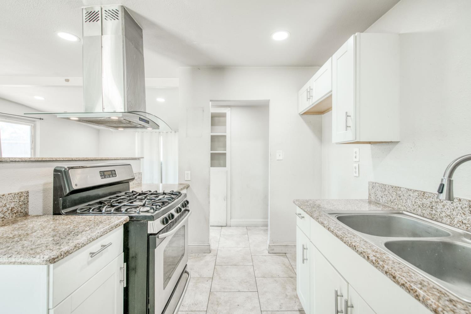 2326 East Hampton Way Fresno, CA 93726 - Photo 9 of 22 a kitchen with granite countertop a sink stove and cabinets