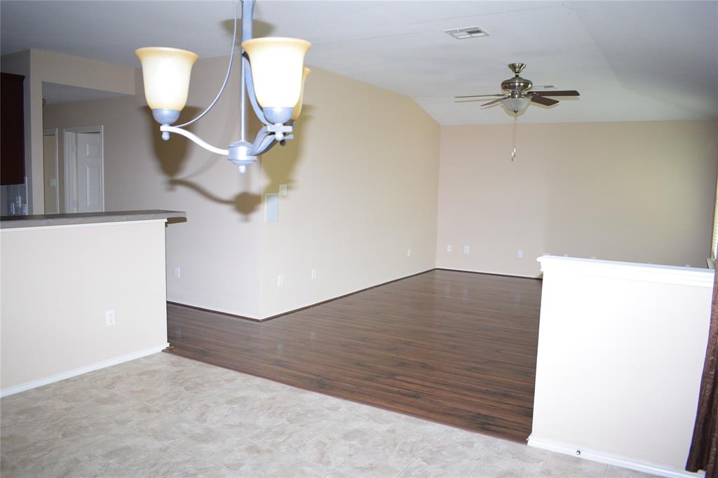 3688 Spring Canyon Trail Round Rock, TX 78681 - Photo 11 of 17 Open concept common area featuring wood-finish flooring, vaulted ceiling, and a ceiling fan
