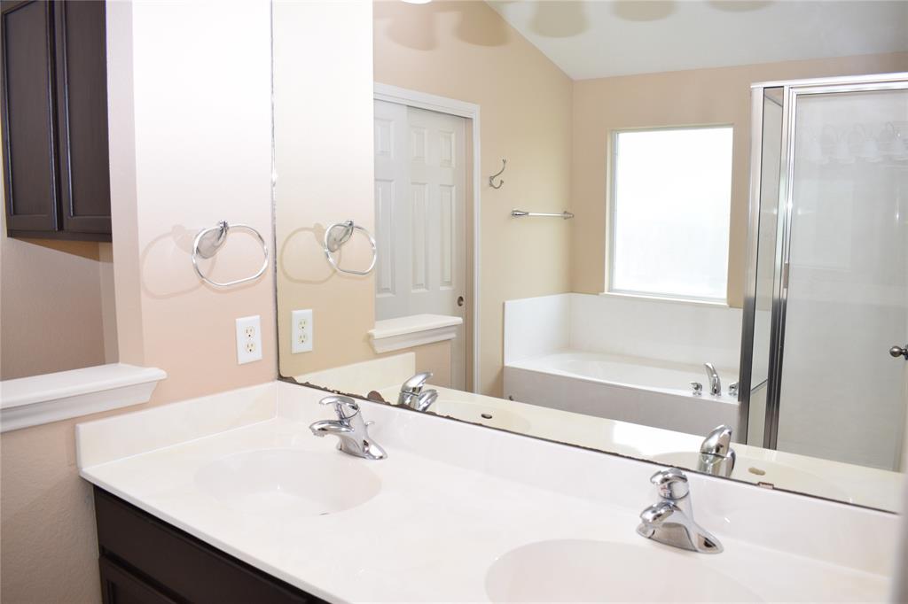 3688 Spring Canyon Trail Round Rock, TX 78681 - Photo 6 of 17 Bathroom featuring a dual vanity with integrated sinks, a built-in tub with deck-mounted fixtures, and a separate shower enclosure with a glass door