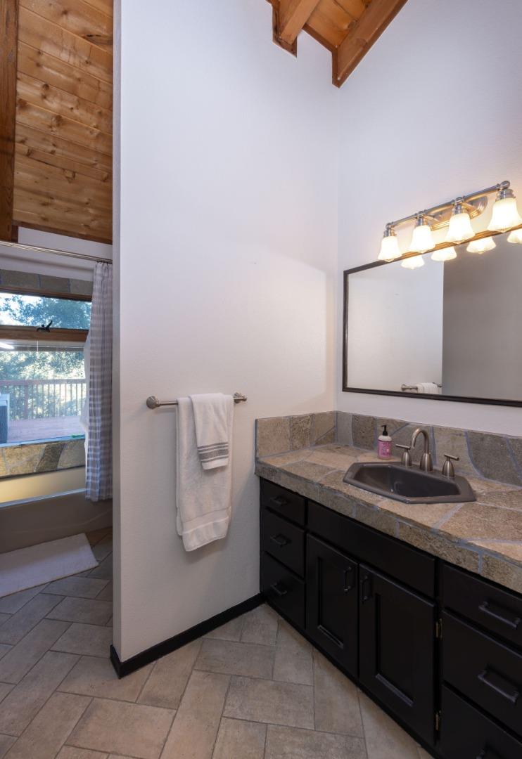 22125 Miller Ridge Road Los Gatos, CA 95033 - Photo 20 of 35 a bathroom with a granite countertop sink and a mirror