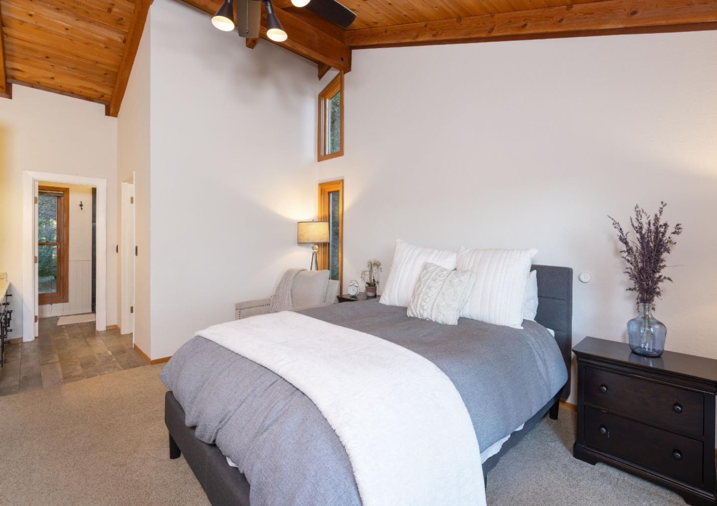 22125 Miller Ridge Road Los Gatos, CA 95033 - Photo 23 of 35 a bedroom with a bed and a lamp on dresser