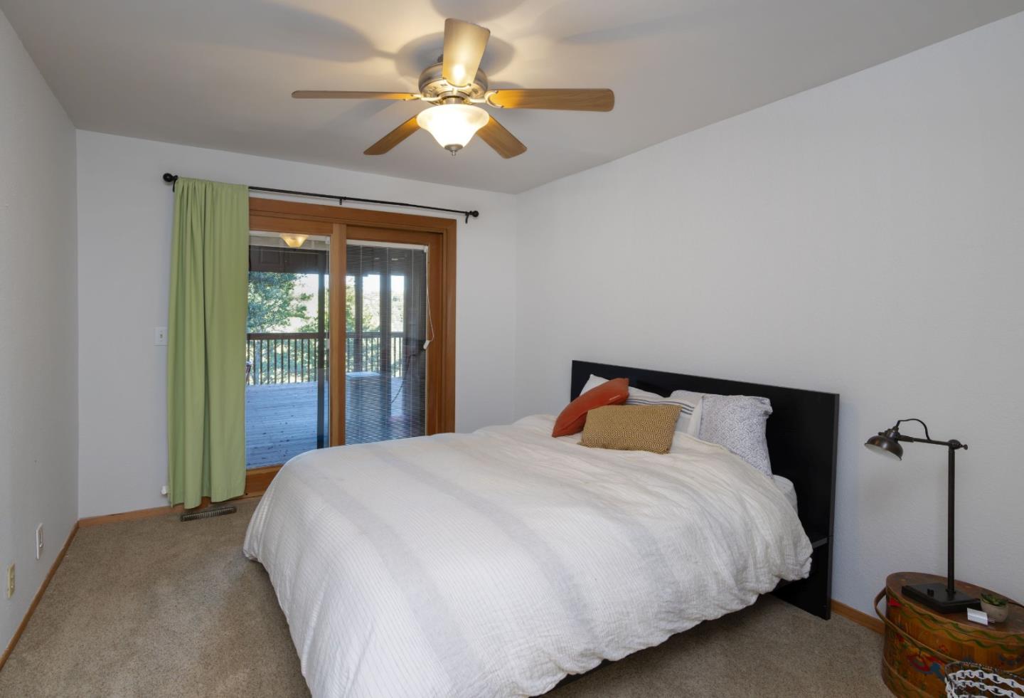 22125 Miller Ridge Road Los Gatos, CA 95033 - Photo 28 of 35 a bedroom with a large bed and a ceiling fan
