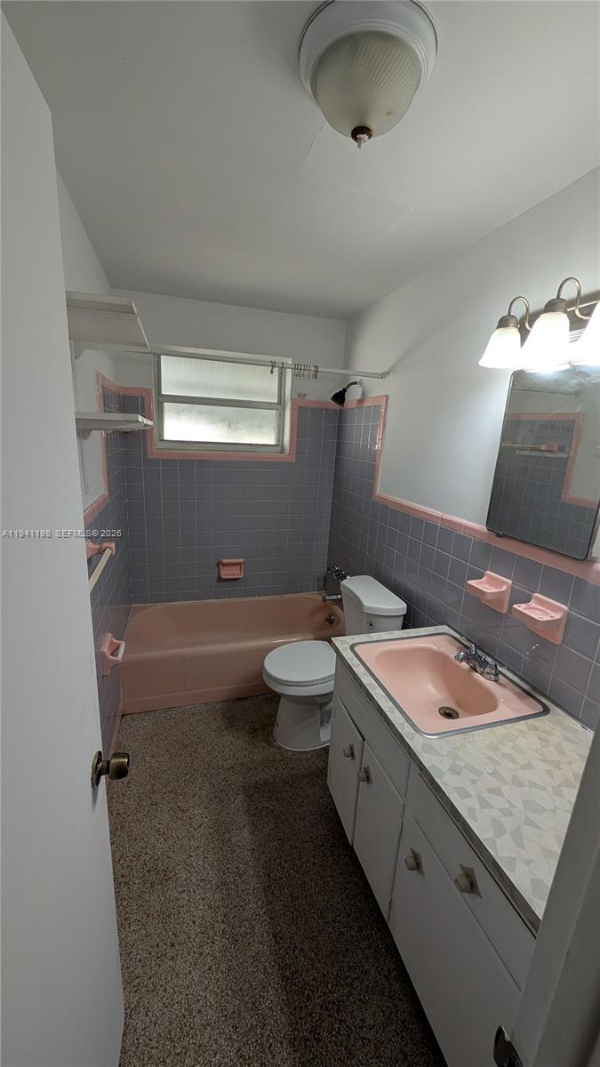 2024 Fillmore Street, Unit 1 Hollywood, FL 33020 - Photo 3 of 5 a bathroom with a granite countertop sink a toilet a mirror and bathtub