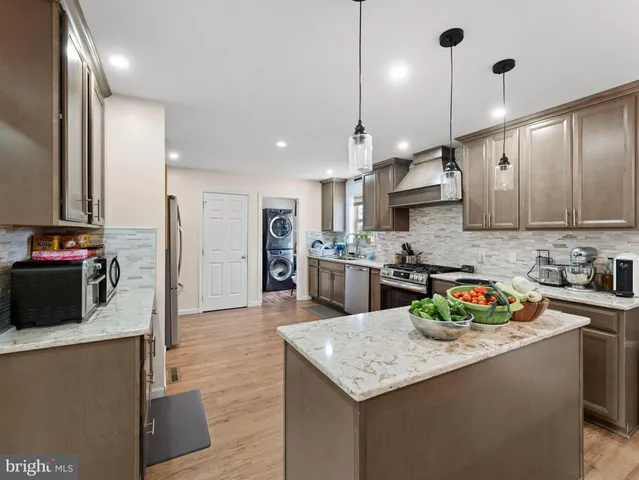 a kitchen with kitchen island granite countertop wooden cabinets and a refrigerator