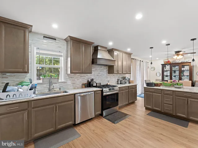 a kitchen with stainless steel appliances granite countertop wooden cabinets stove top oven and sink
