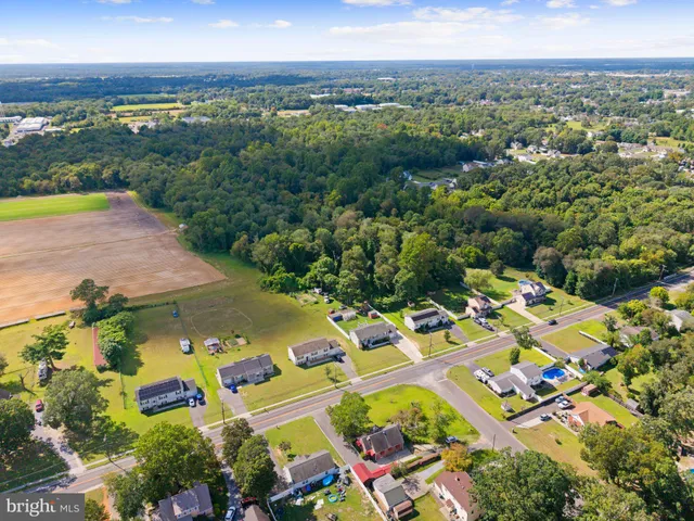 an aerial view of a city with lots of residential buildings ocean and mountain view in back