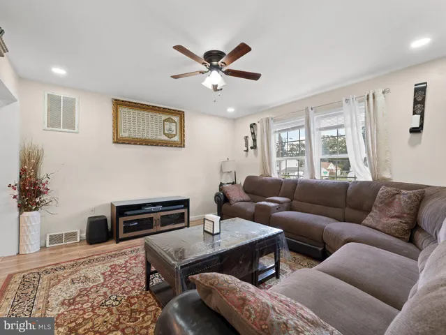 a living room with furniture a flat screen tv and a window