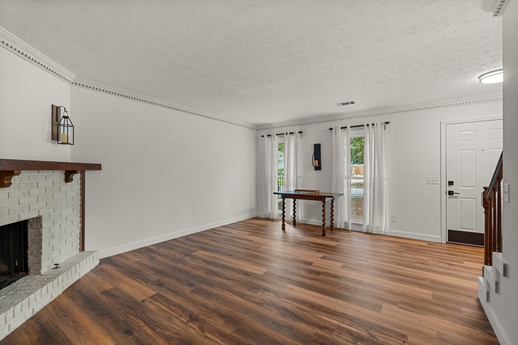 2133 13th Street Columbus, GA 31906 - Photo 11 of 15 a view of empty room with wooden floor and fireplace