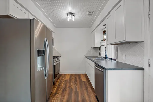 a kitchen with stainless steel appliances granite countertop a refrigerator and a sink
