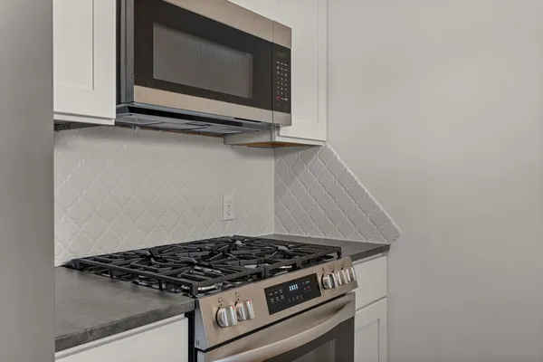a stove top oven sitting inside of a kitchen
