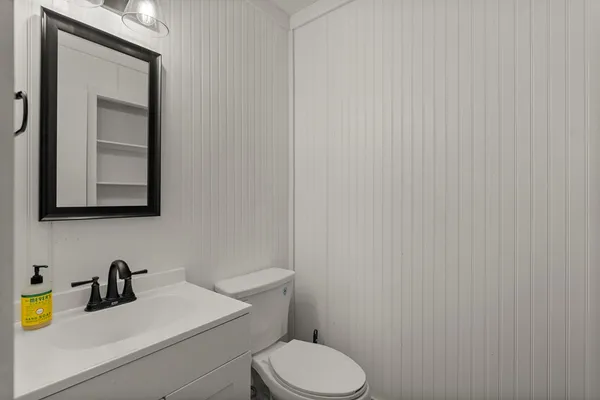 a bathroom with a toilet a sink and mirror
