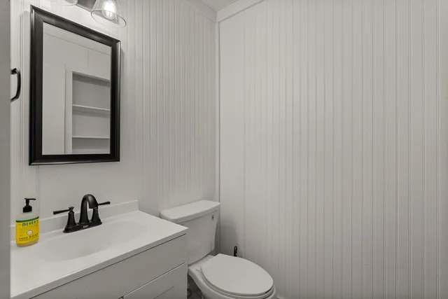 a bathroom with a toilet a sink and mirror