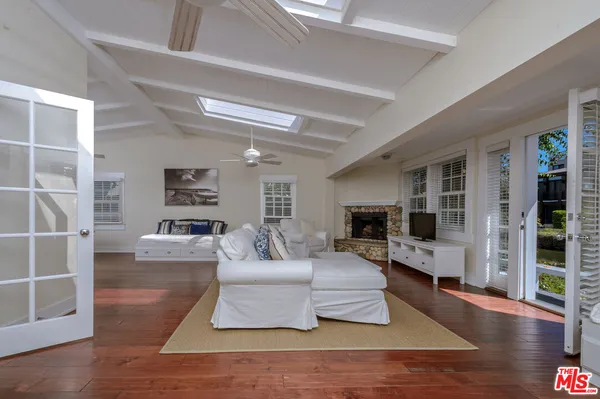 a living room with furniture large window and wooden floor