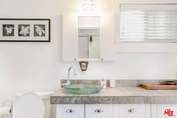 a bathroom with a granite countertop sink and a mirror