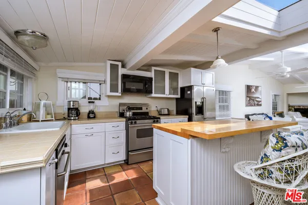 a kitchen with stainless steel appliances granite countertop a sink dishwasher a stove a refrigerator oven with a dining table and chairs with wooden floor