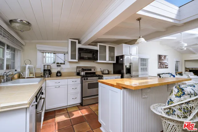 a kitchen with stainless steel appliances granite countertop a sink dishwasher a stove a refrigerator oven with a dining table and chairs with wooden floor