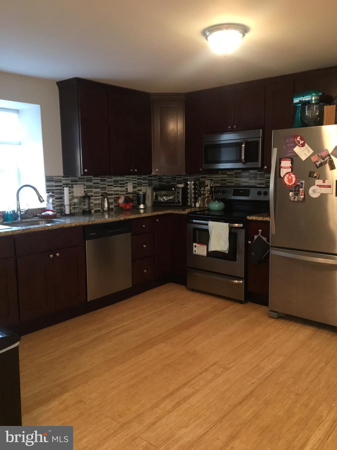 4203 Main Street, Unit 2 Philadelphia, PA 19127 - Photo 5 of 16 a kitchen with stainless steel appliances granite countertop a stove a sink and a microwave