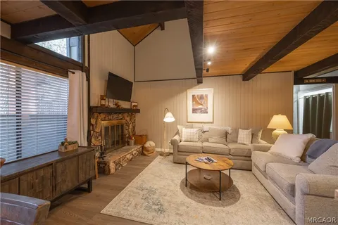 a living room with fireplace furniture and a wooden floor