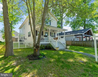 a view of a house with backyard and a tree