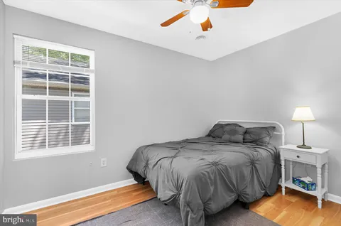 a bedroom with a bed and a potted plant on dresser