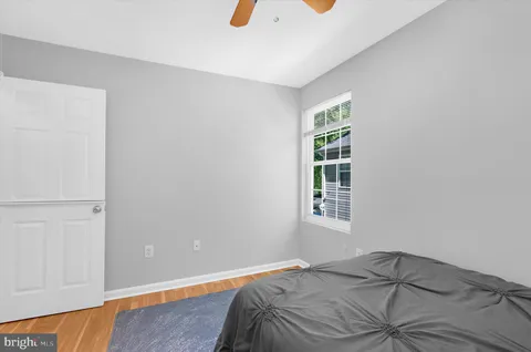 a bedroom with a large bed and a chandelier fan