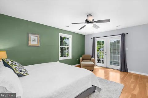 a bedroom with a bed a dresser and a chandelier