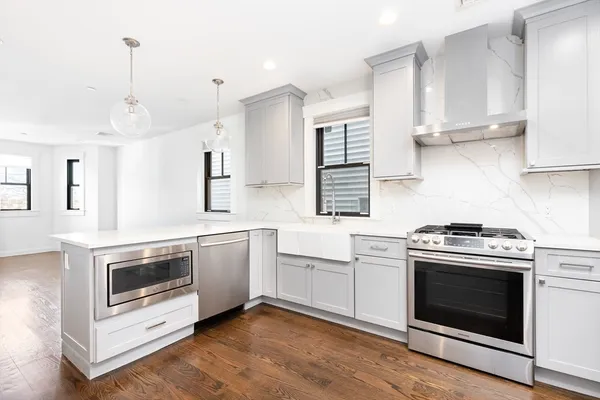 a kitchen with white cabinets and stainless steel appliances