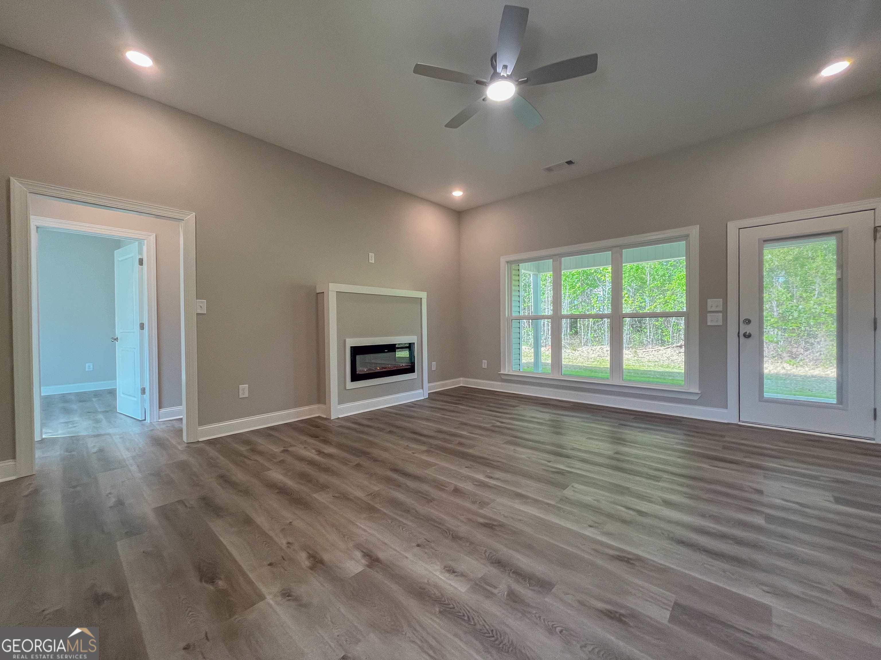 711 Flanders Lane Dublin, GA 31021 - Photo 9 of 49 an empty room with wooden floor chandelier and glass door