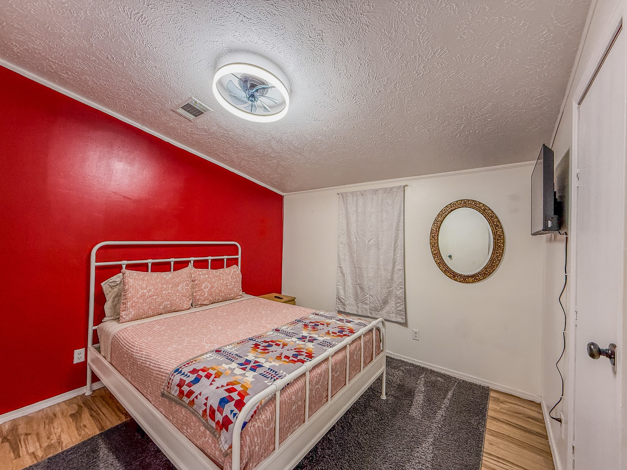 2015 Holly Street Austin, TX 78702 - Photo 9 of 24 A well-lit bedroom featuring a stylish bed and wood flooring.