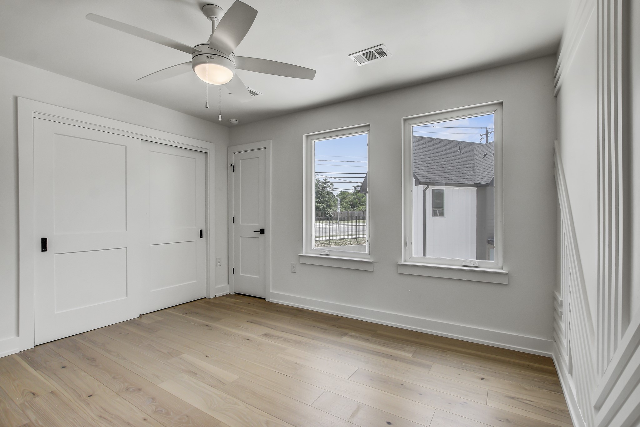 4127 East 12th Street, Unit 5 Austin, TX 78721 - Photo 8 of 33 Unfurnished bedroom featuring baseboards, light wood finished floors, a ceiling fan, and a closet