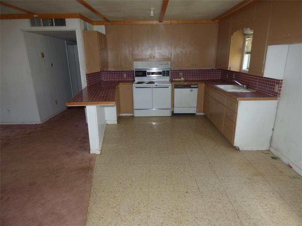 309 East 10th Street Cisco, TX 76437 - Photo 15 of 35 a kitchen with stainless steel appliances granite countertop a sink stove and refrigerator