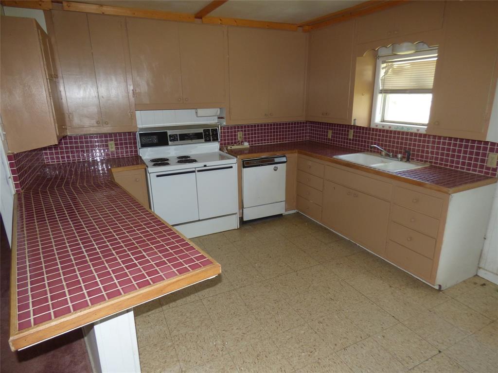 309 East 10th Street Cisco, TX 76437 - Photo 16 of 35 a kitchen with a sink and cabinets
