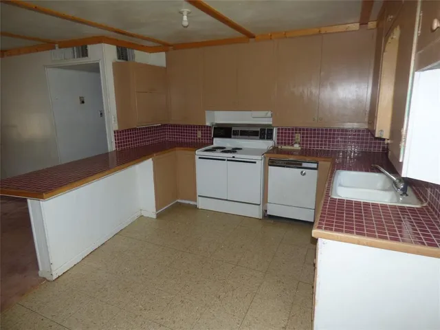 a kitchen with a cabinets and white appliances