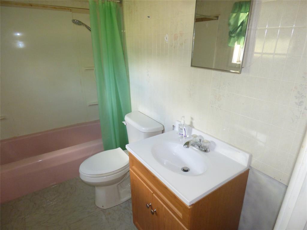 309 East 10th Street Cisco, TX 76437 - Photo 31 of 35 a bathroom with a sink a toilet and shower
