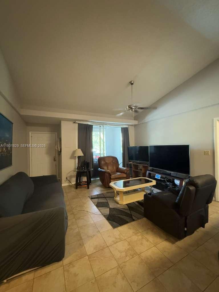 621 Lyons Road, Unit 9201 Coconut Creek, FL 33063 - Photo 3 of 28 a living room with furniture and a flat screen tv