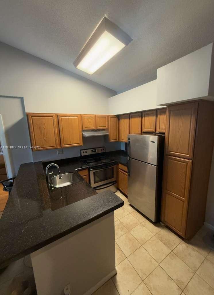621 Lyons Road, Unit 9201 Coconut Creek, FL 33063 - Photo 4 of 28 a kitchen with stainless steel appliances granite countertop a refrigerator and a counter space
