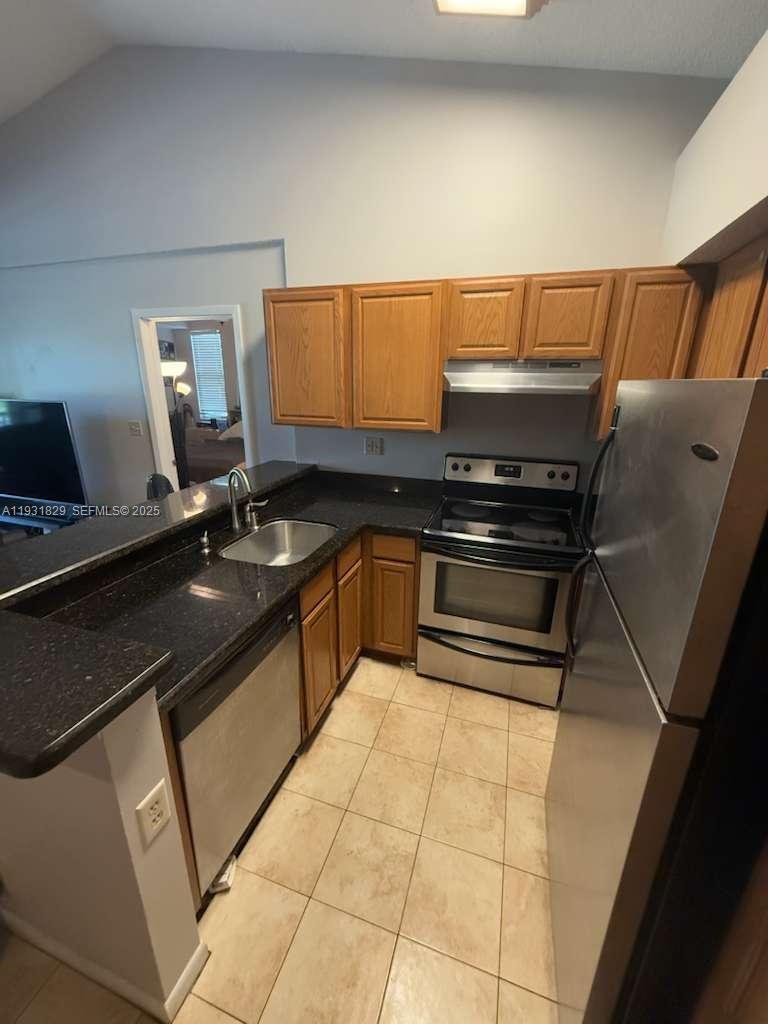 621 Lyons Road, Unit 9201 Coconut Creek, FL 33063 - Photo 5 of 28 a kitchen with granite countertop a sink and cabinets