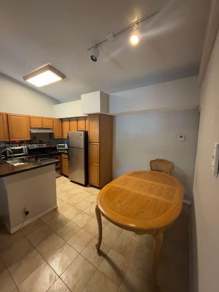 621 Lyons Road, Unit 9201 Coconut Creek, FL 33063 - Photo 7 of 28 a kitchen with stainless steel appliances kitchen island granite countertop a refrigerator a stove a sink and a microwave