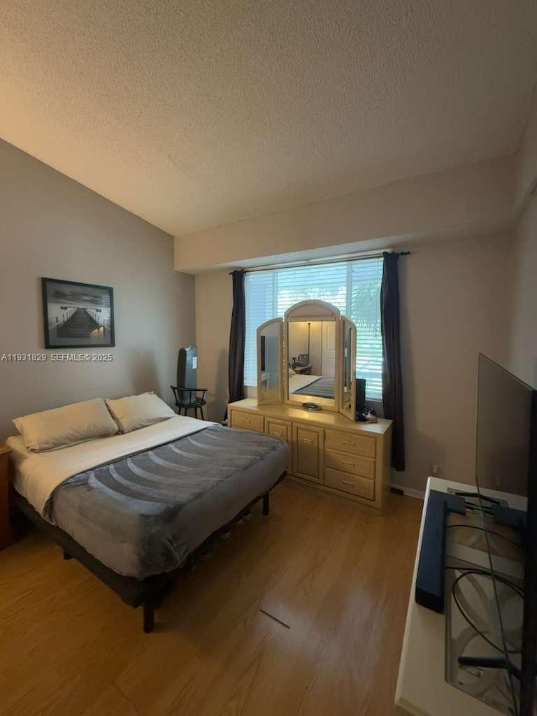 621 Lyons Road, Unit 9201 Coconut Creek, FL 33063 - Photo 9 of 28 a bedroom with a bed and a flat screen tv