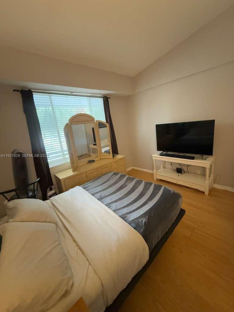 621 Lyons Road, Unit 9201 Coconut Creek, FL 33063 - Photo 10 of 28 a bedroom with a bed and a flat screen tv
