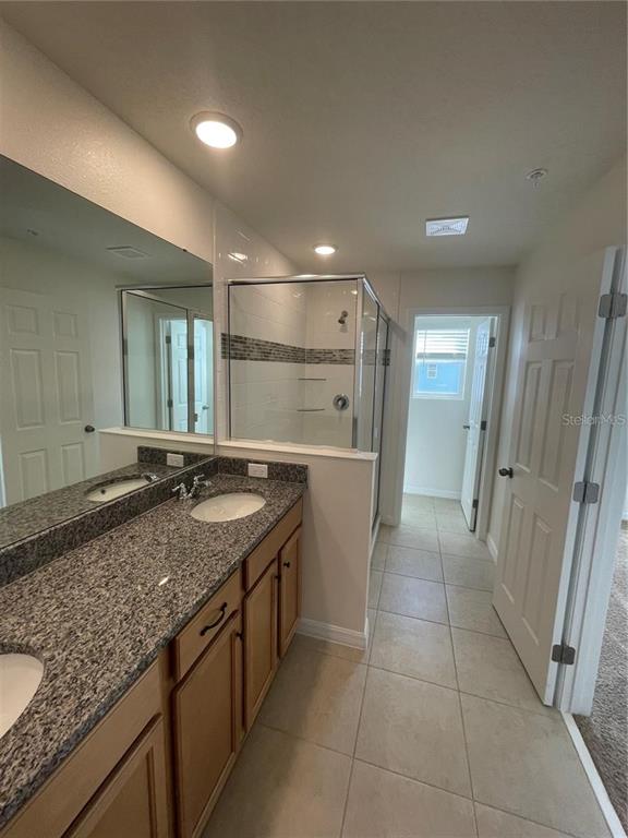 12264 Linear Street Orlando, FL 32832 - Photo 9 of 10 a bathroom with a granite countertop sink a mirror and a vanity