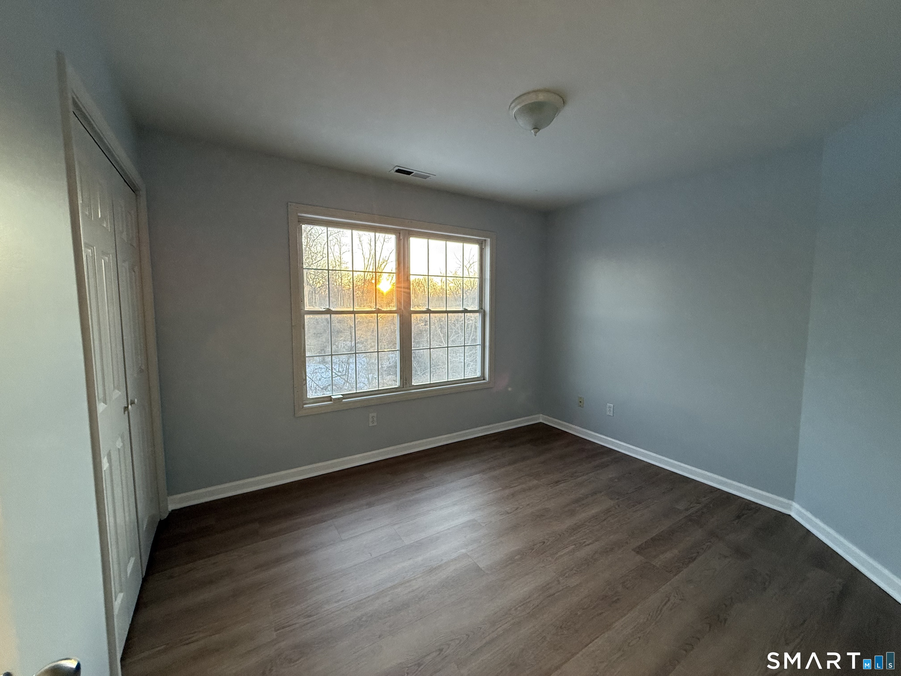 156 3rd Avenue West Haven, CT 06516 - Photo 3 of 17 an empty room with wooden floor and windows