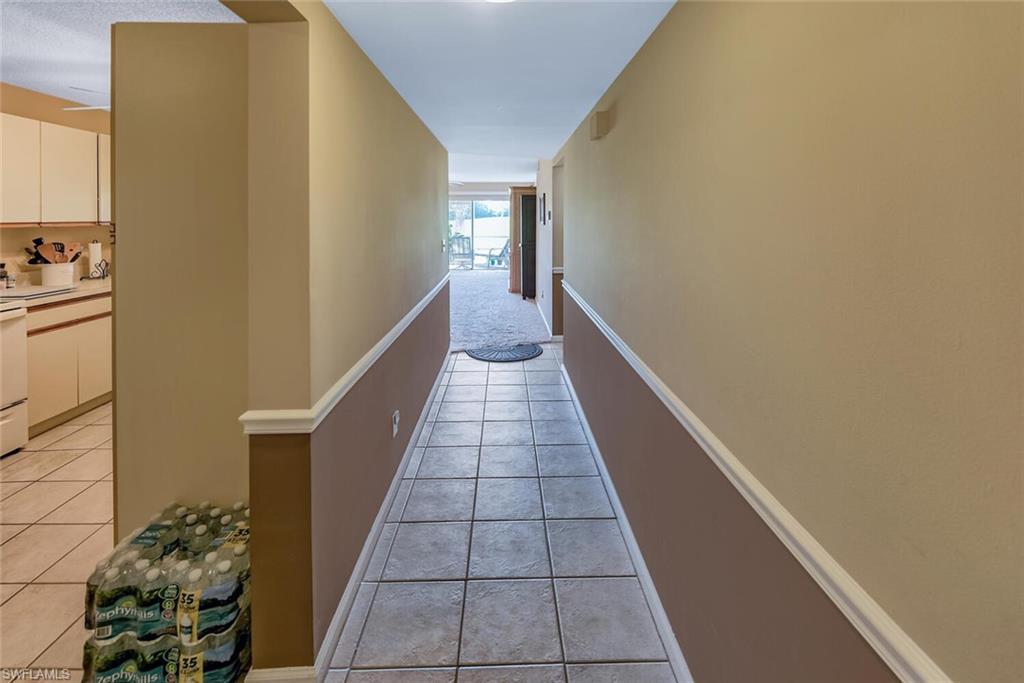 780 Augusta Boulevard, Unit C102 Naples, FL 34113 - Photo 12 of 26 a view of a hallway with wooden floor and staircase