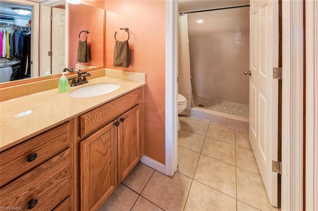 780 Augusta Boulevard, Unit C102 Naples, FL 34113 - Photo 15 of 26 a bathroom with a sink a toilet and shower