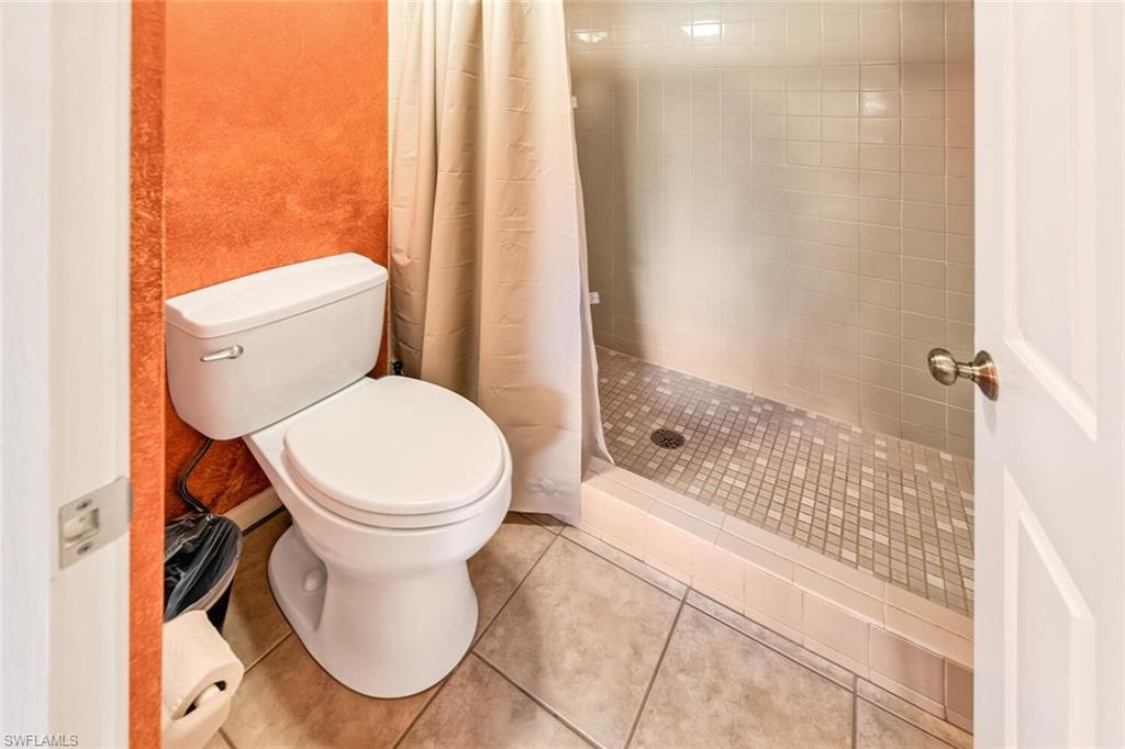 780 Augusta Boulevard, Unit C102 Naples, FL 34113 - Photo 16 of 26 a white toilet sitting next to a bath tub