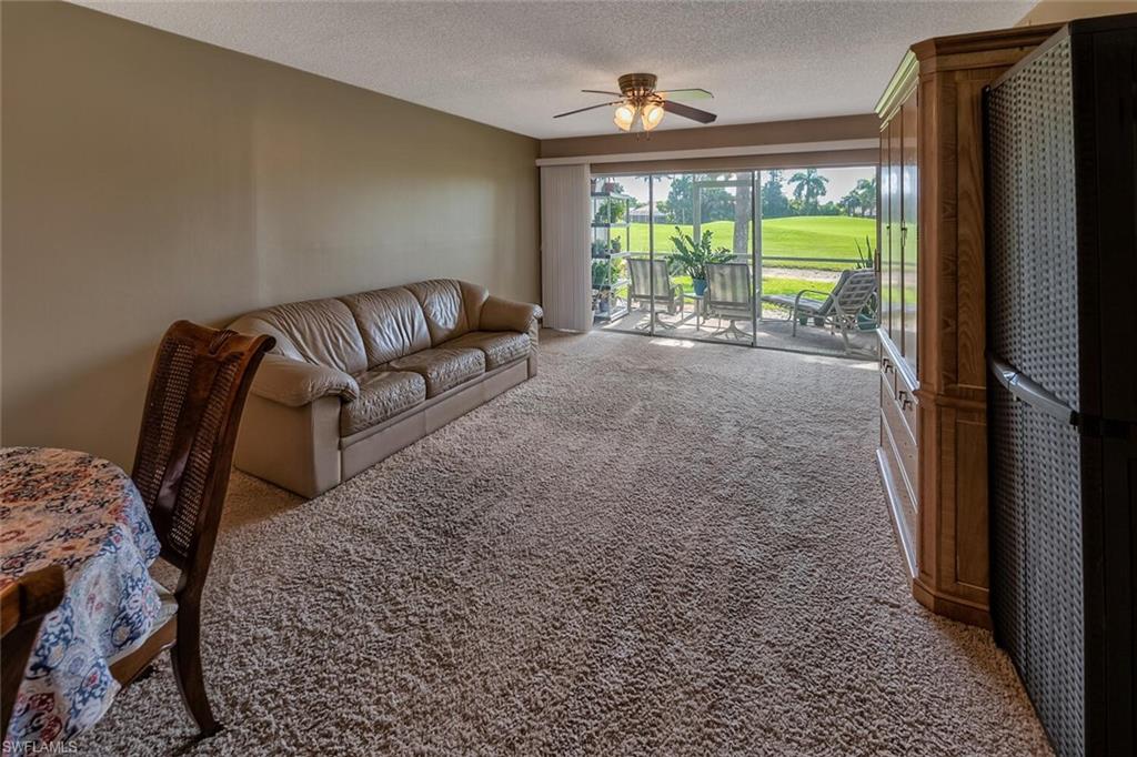 780 Augusta Boulevard, Unit C102 Naples, FL 34113 - Photo 7 of 26 a living room with furniture and a floor to ceiling window