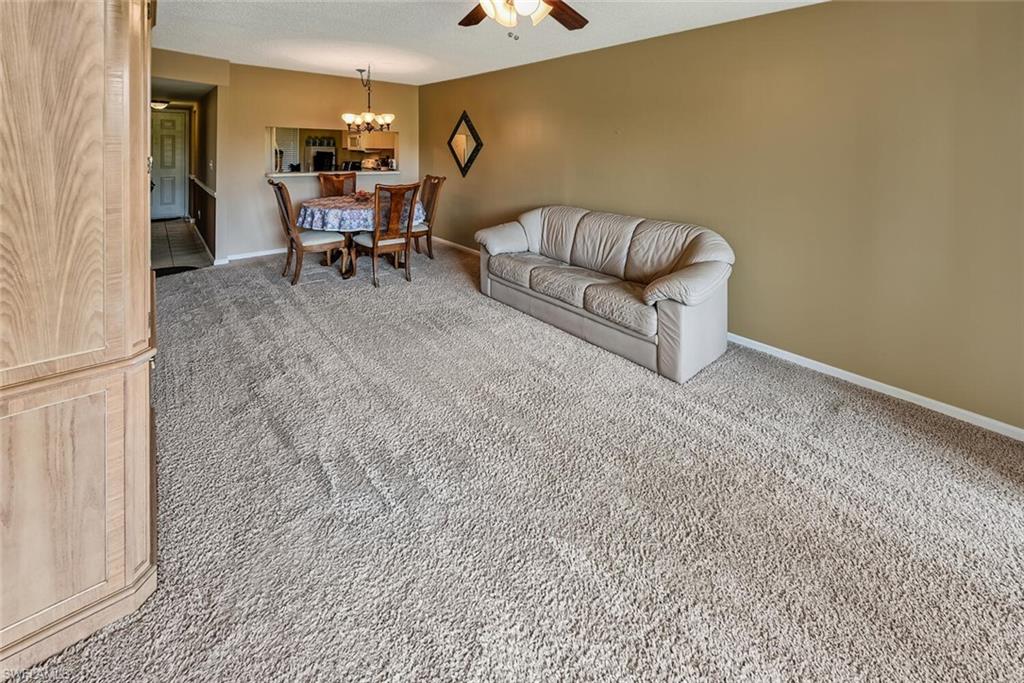 780 Augusta Boulevard, Unit C102 Naples, FL 34113 - Photo 8 of 26 a living room with furniture and a piano