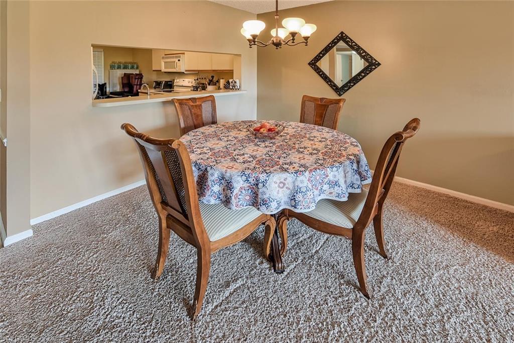 780 Augusta Boulevard, Unit C102 Naples, FL 34113 - Photo 9 of 26 a dining room with furniture and window