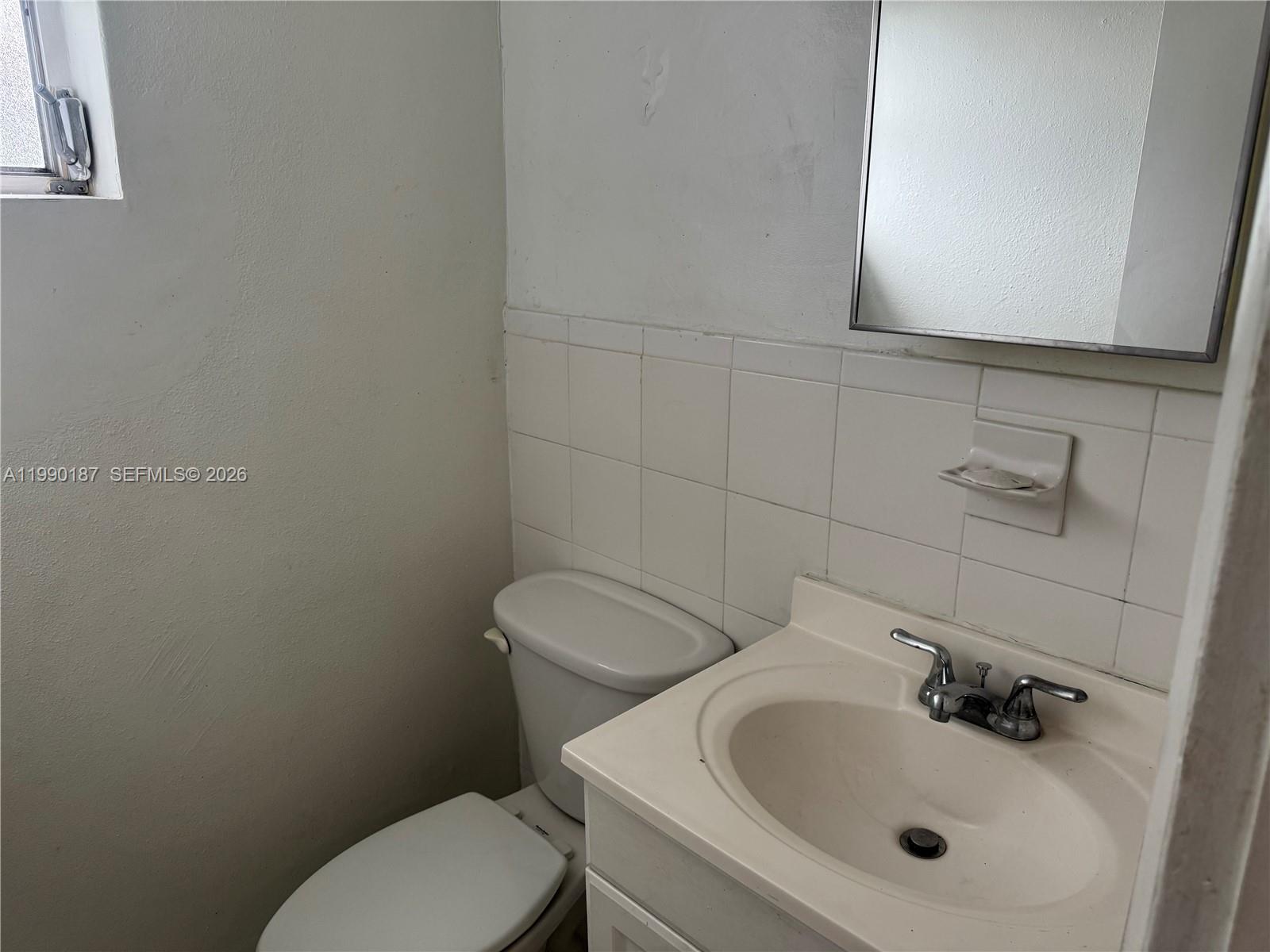 11 Southwest 32nd Avenue, Unit 4 Miami, FL 33135 - Photo 8 of 13 a bathroom with a toilet sink and mirror