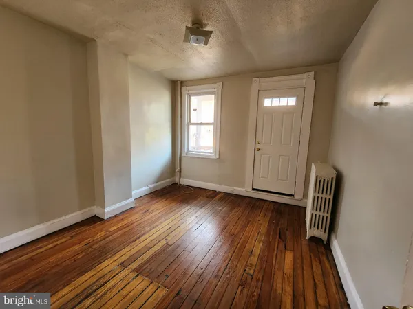 a view of a room with wooden floor and window